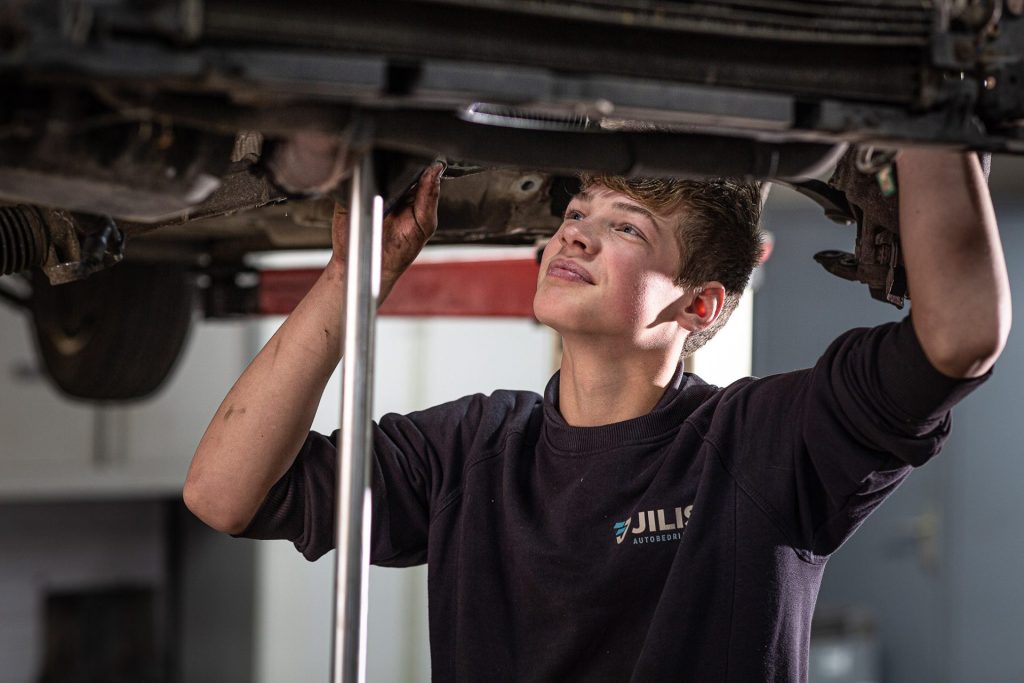 professioneel bedrijf foto van autobedrijf garage met jongen aan het werk - mooimerk