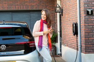 professioneel bedrijf foto van vrouw op elektrische auto aan het opladen - mooimerk